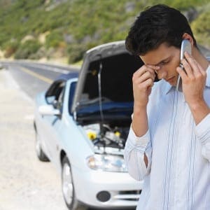 Close up of Young Man talking on mobile phone with car hood open Close-up-of-young-man-talking-on-mobile-phone-with-car-bonnet-open